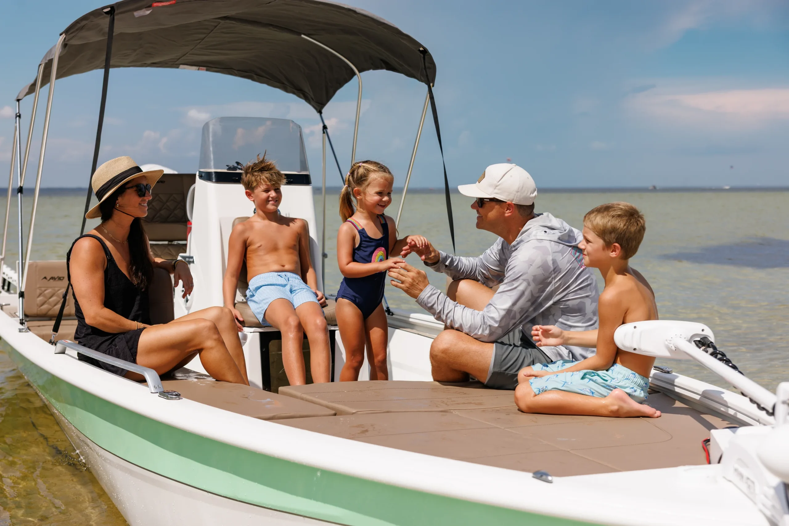 A family gathered on the bow seating of the Avid 23 Fusion